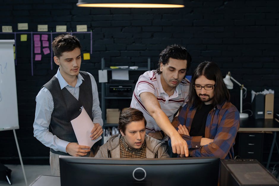 Group of professionals discussing a project at a computer in a modern office environment